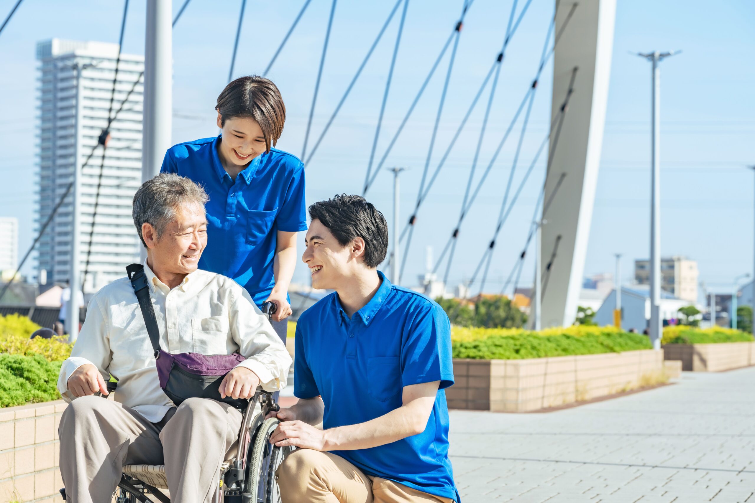スタッフ２人と車椅子のご利用者の散歩風景